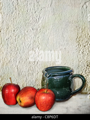 Still life, a green rustic water jug and three red apples on a marble table against a white rough wall Stock Photo