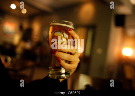 A woman holds a glass filled with the local Palestinian Taybeh beer in a bar in Ramallah a Palestinian city in the central West Bank in the Palestinian territories