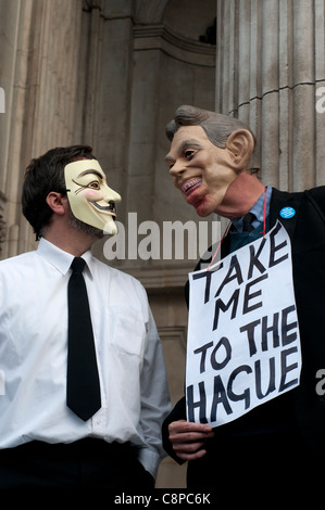 Occupy London Stock Exchange Protester wearing Guy Fawkes mask talking to a man wearing a Tony Blair mask and holding sign Stock Photo