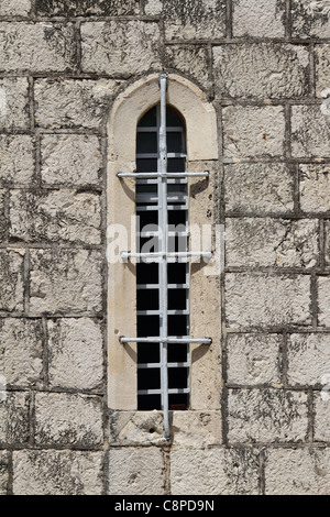 Vrboska on Hvar island - old church window with grating and iron bar Stock Photo