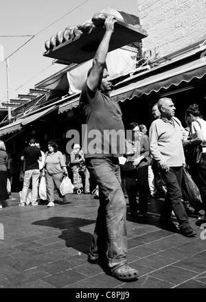 A man carrying a load of fresh bread from the bakery Stock Photo