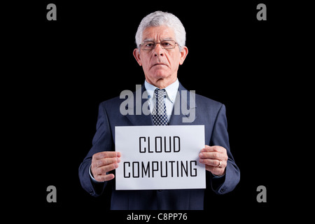 Senior businessman holding a paper with the Cloud Computing words (isolated on black) Stock Photo