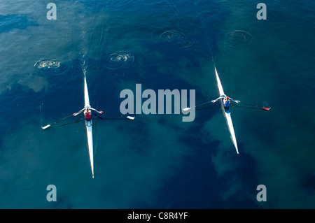 People rowing sculling boats on river Stock Photo