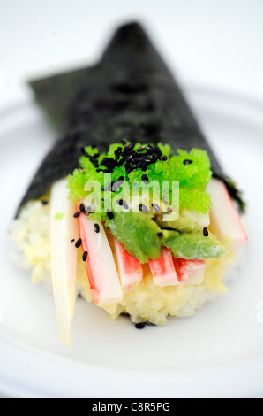 Close up of California Roll sushi. Crabsicks, avocado rice and sesame seeds wrapped in seaweed. Stock Photo