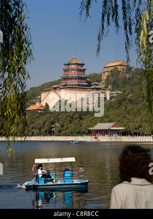 Tourist watching paddle boaters on Kunming Lake Buddhist Fragrance temple at Summer Palace Beijing Peoples Republic of China Stock Photo