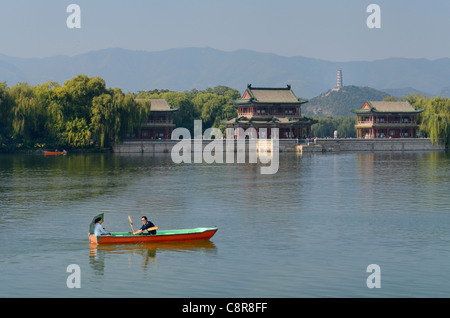 Couple rowing past the Pavilion of Bright Scenery with Jade Peak Pagoda on Kunming Lake Summer Palace Beijing Peoples Republic of China