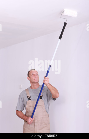 Man repainting ceiling Stock Photo