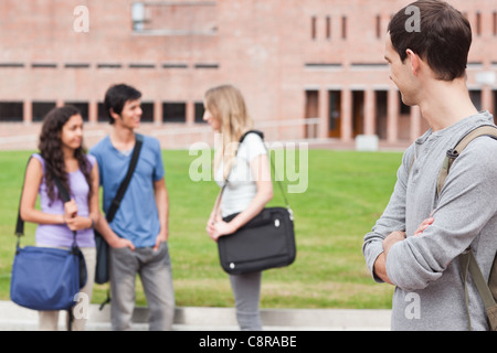 Student looking at his classmates talking Stock Photo