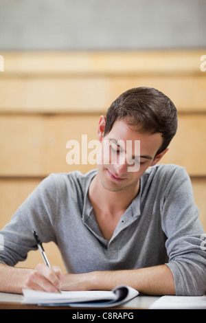 Portrait of a male student writing on a notepad Stock Photo