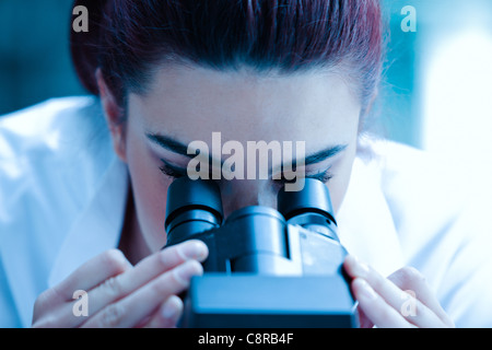 Young scientist looking through a microscope Stock Photo