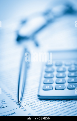 Piece of paper, pen, glasses and pocket calculator Stock Photo
