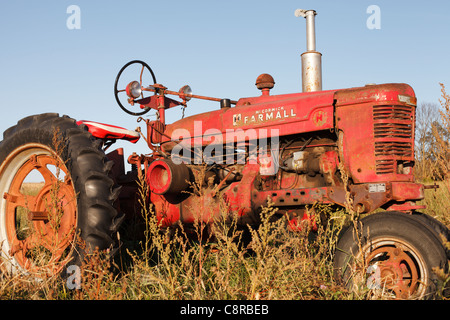 An old McCormick Farmall tractor sitting in a field. Stock Photo