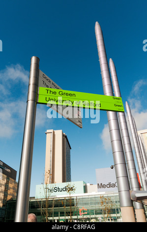 A sign points to The Green and University of Salford at MediaCityUK, Salford Quays, Manchester Stock Photo