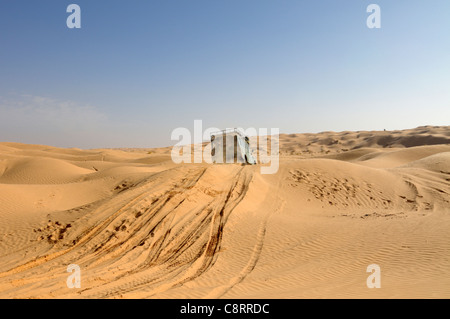 Africa, Tunisia, nr. Tembaine. Desert travellers driving their 1975 Land Rover Series 3 Station Wagon through a sandfield ... Stock Photo