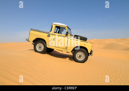 Africa, Tunisia, nr. Tembaine. Desert traveller driving his 1964 Land Rover Series 2a Truck Cab through a sandfield close to ... Stock Photo