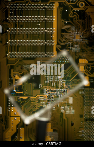 Looking at circuit board through magnifying glass Stock Photo - Alamy