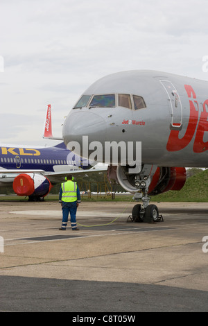 Boeing 757 on apron with technician doing engine run-ups Stock Photo