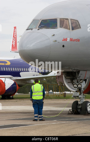 Boeing 757 on apron with technician doing engine run-ups Stock Photo