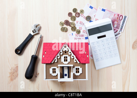 Top view of model home surrounded with calculator, money and tools Stock Photo