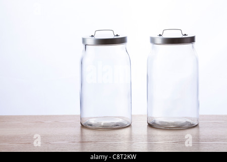 Two empty glass jar with lid closed against white background Stock Photo