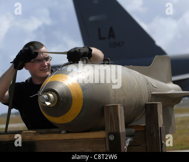 Airman 1st Class Jason Stromberg straps down a live 750 pound M117 bomb onto a specialized bomb lift for loading on to a B-52 Stratofortress. The 96th Expeditionary Bomb Squadron will later drop the bombs on the Farallon de Medinilla Target Range; an uninhabited island located about 150 miles north of Guam. The bomber's participation in constant training helps emphasize the U.S. bomber presence, demonstrating U.S. commitment to the Pacific region. Airman Stromberg is with the with the 36th Expeditionary Aircraft Maintenance Squadron and is deployed from the 2nd Bomb Wing, Barksdale, AFB, Ala. Stock Photo