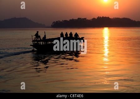 A boat at sunset on the Brahmaputra River, Assam, India Stock Photo