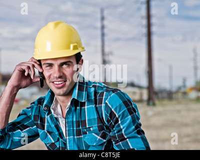 Smiling construction worker talking on cell phone Stock Photo
