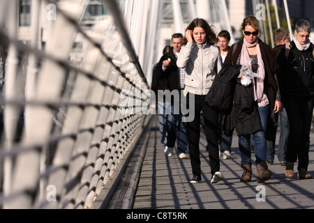a low view along The Golden Jubilee Bridge, London, with people walking towards the camera Stock Photo