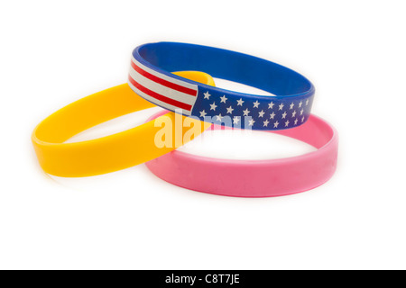 Three cause bands arranged together with a yellow band, a pink band, and an American red white and blue wrist band. Stock Photo