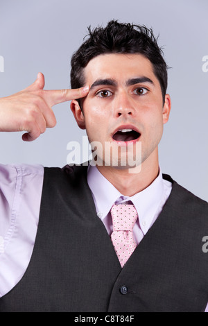 Young businessman despair pointing his finger to his head like shooting a gun Stock Photo