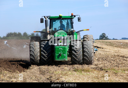 Big tractor pull a plough on a late summer stubble field. Mid Zealand, Denmark. Stock Photo