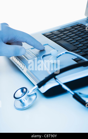 Studio shot of doctor's hand touching laptop Stock Photo