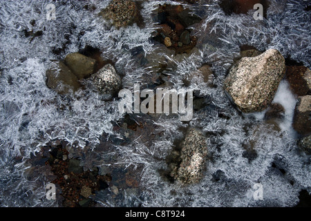 Frozen river bed with frosty patterns and rock details Stock Photo