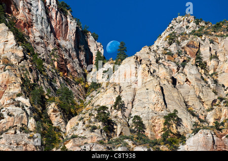 Moon descending between two mountain peaks at Zion National Park, Utah, USA. Stock Photo
