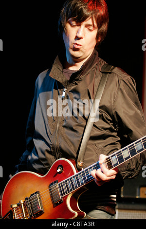 Mark Collins of the English rock band, The Charlatans plays guitar at an in-store gig at a Zavvi store in London's Oxford Street Stock Photo