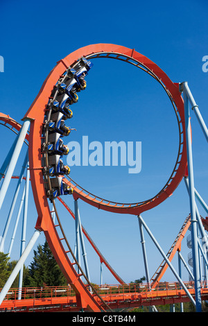 People riding on the Dragon Khan roller coaster in Port Aventura amusement park. Salou, Catalonia, Spain. Stock Photo