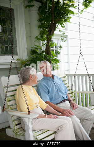 USA, New York State, Old Westbury, Senior couple sitting on porch swing Stock Photo