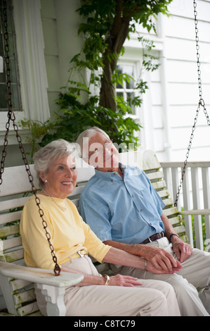 USA, New York State, Old Westbury, Senior couple sitting on porch swing Stock Photo