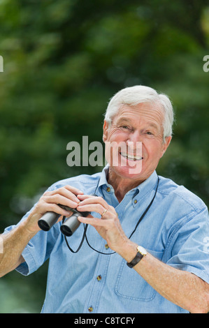 USA, New York State, Old Westbury, Senior man with binoculars Stock Photo