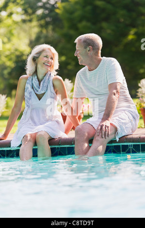 USA, New York State, Old Westbury, Senior couple at edge of swimming pool Stock Photo