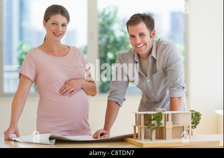 USA, New Jersey, Jersey City, Young couple with blueprints and house model Stock Photo