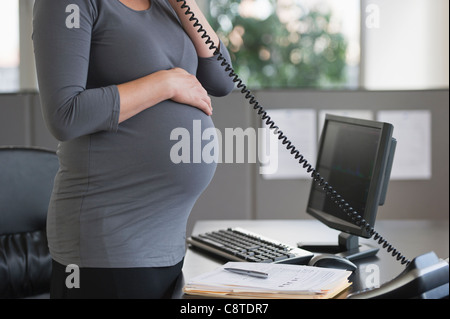 USA, New Jersey, Jersey City, Young pregnant woman working in office Stock Photo