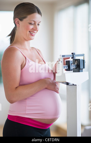 USA, New Jersey, Jersey City, Pregnant woman weighing herself Stock Photo