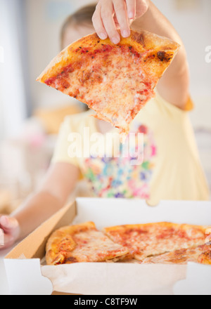 USA, New Jersey, Jersey City, Girl showing slice of pizza Stock Photo