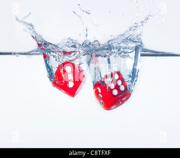 Two dices splashing into water, studio shot Stock Photo