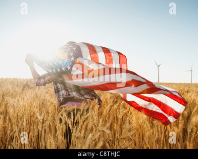 USA, Oregon, Wasco, Girl flying american flag in wheat field