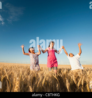 USA, Oregon, Wasco, Girls and boy walking though wheat field Stock Photo