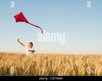 USA, Oregon, Wasco, Boy playing with kite in wheat field Stock Photo