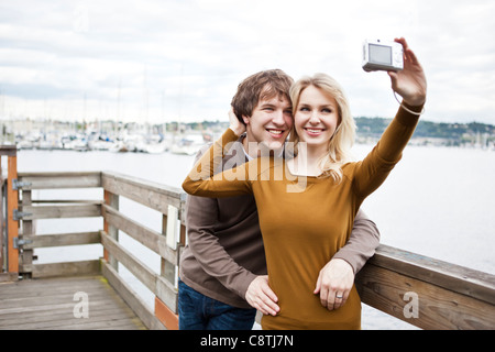 USA, Washington, Seattle, Young couple taking photos on pier Stock Photo