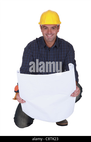 Smiling tradesman looking at a blueprint Stock Photo